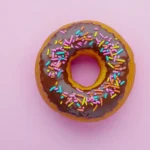 A close-up of a chocolate frosted donut, glossy frosting, high-quality, hyperrealistic.