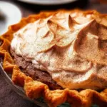 Slice of homemade apple butter pie topped with whipped cream.